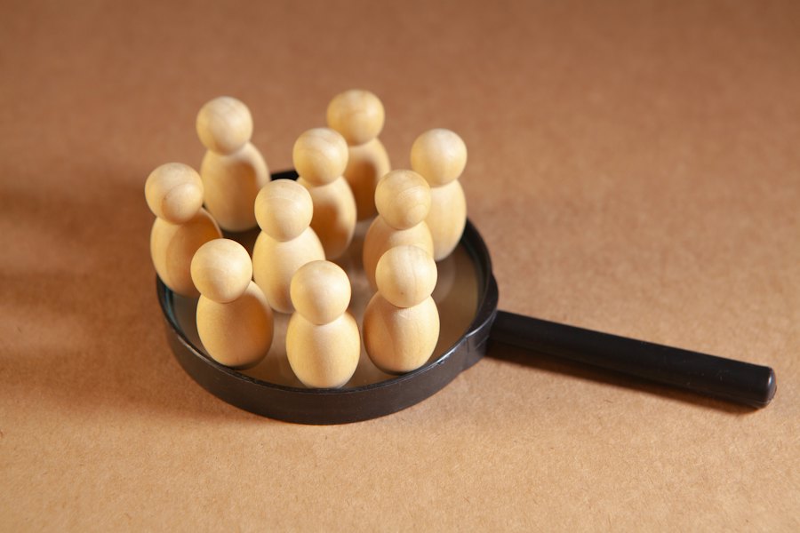 Figuras de madera agrupadas sobre una lupa