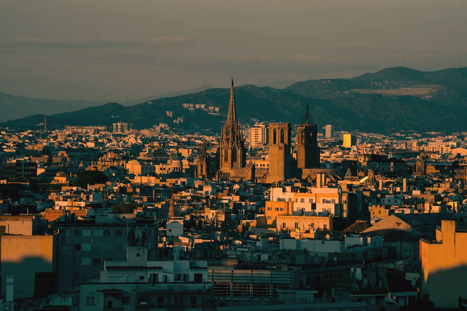 Barcelona al atardecer vista desde lo alto, con la catedral en el centro y la sierra de Collserola al fondo.