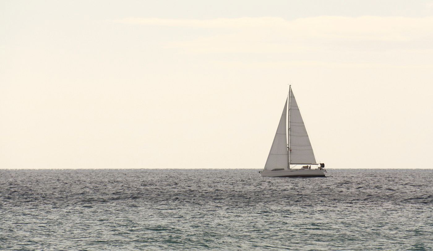 Un velero navega solo en mar abierto.